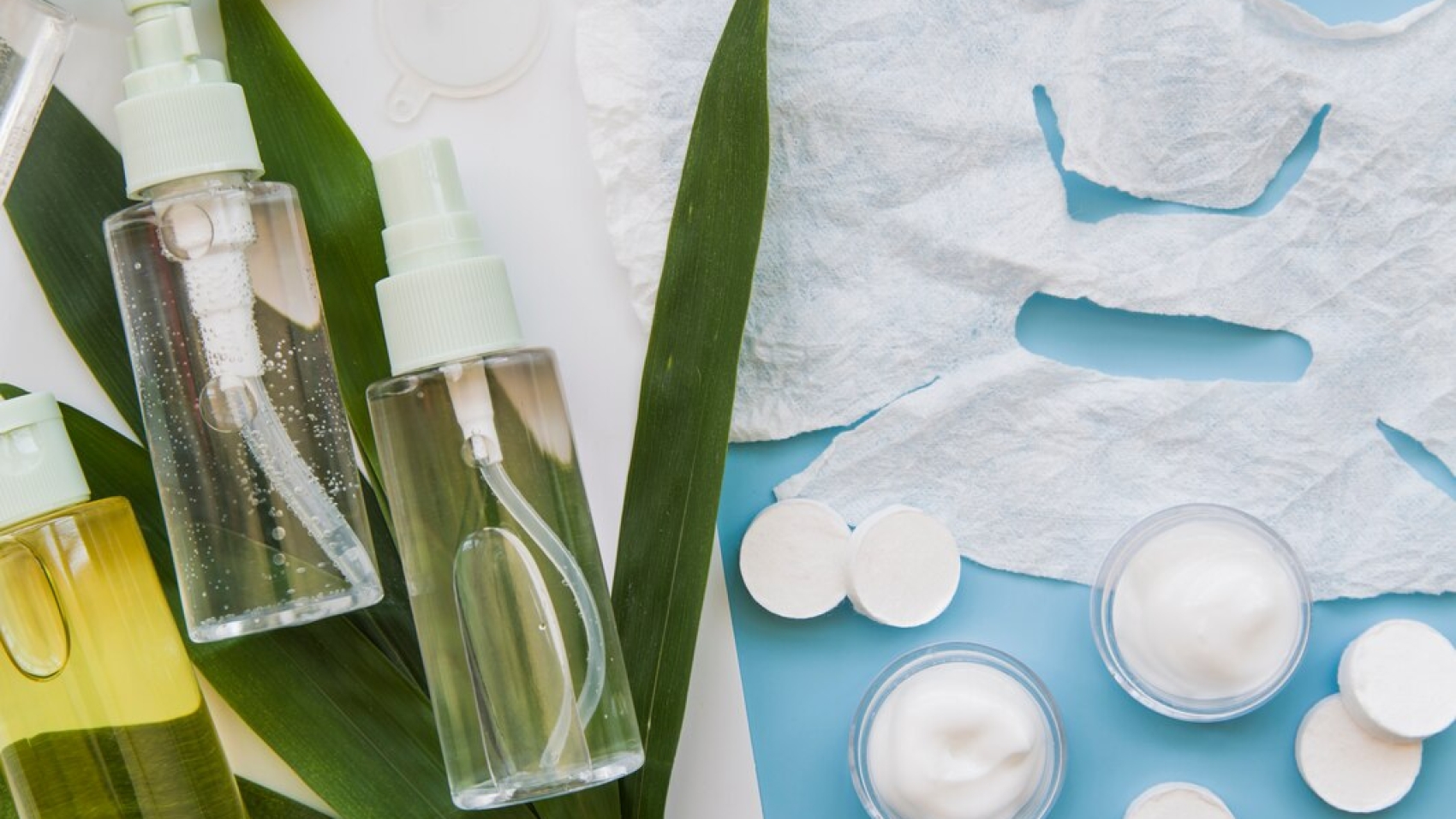 paper-sheet-face-mask-cream-herbal-spray-bottles-with-leaves-blue-backdrop_23-2148031346