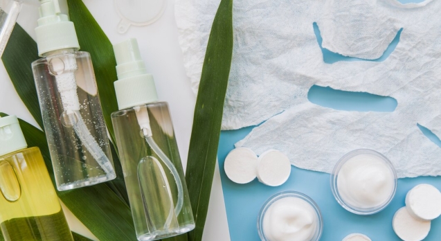 paper-sheet-face-mask-cream-herbal-spray-bottles-with-leaves-blue-backdrop_23-2148031346